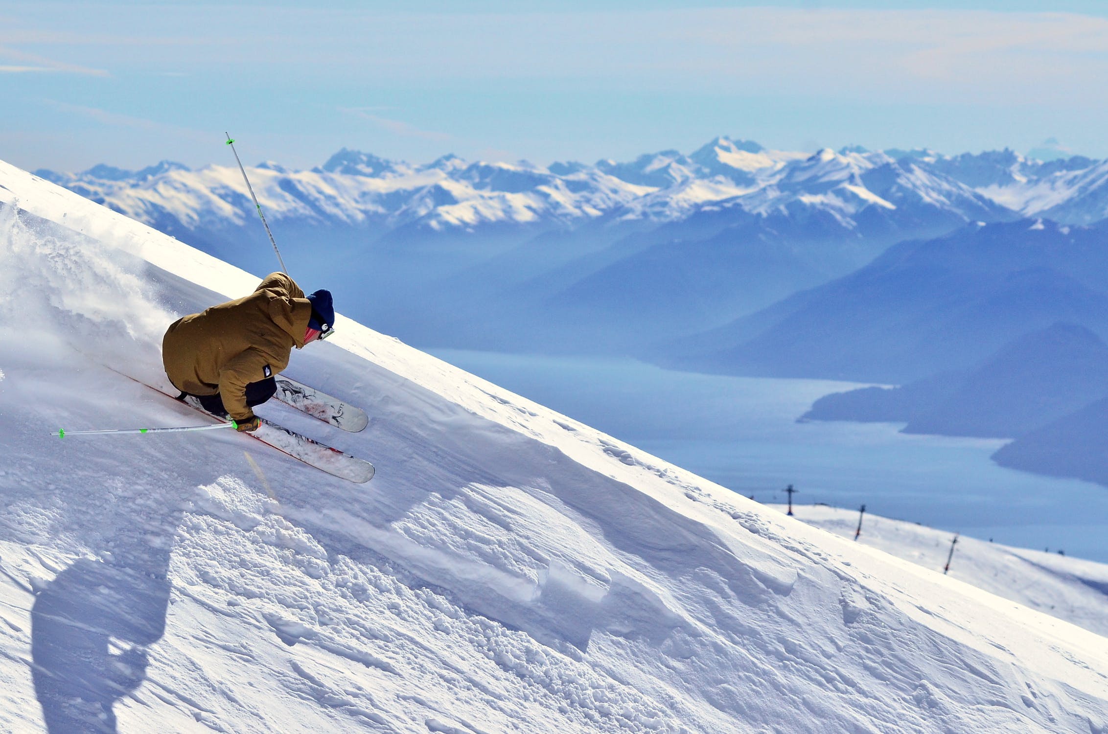 Foto di un ragazzo mentre sta sciando in una pista da scii su montagne coperte completamente di neve