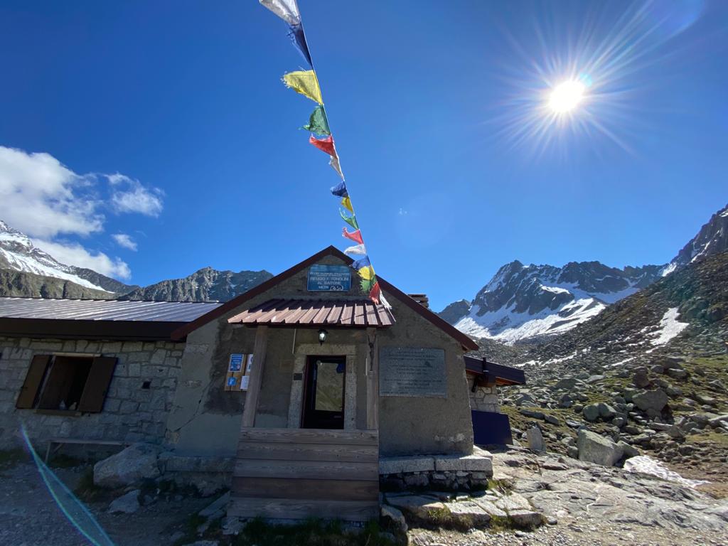 Foto di un rifugio alpino ed un sole splendente