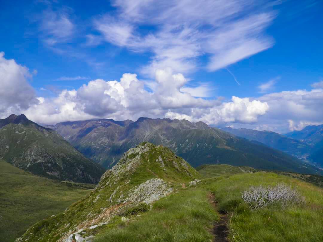 Vista da una bassa montagna verde con in sottofondo un cielo limpido