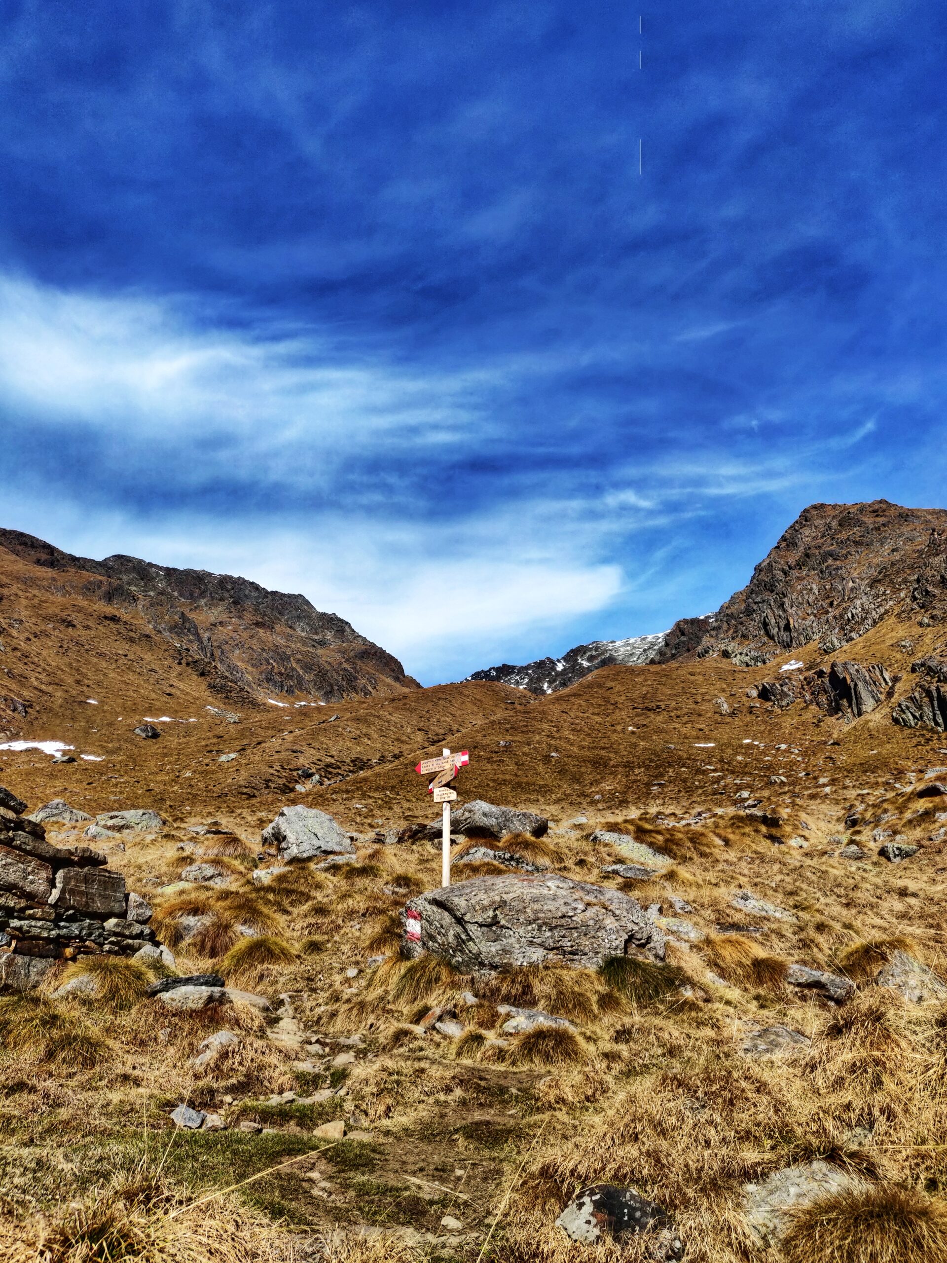 Foto di un palo con delle indicazioni in mezzo alle montagne aride