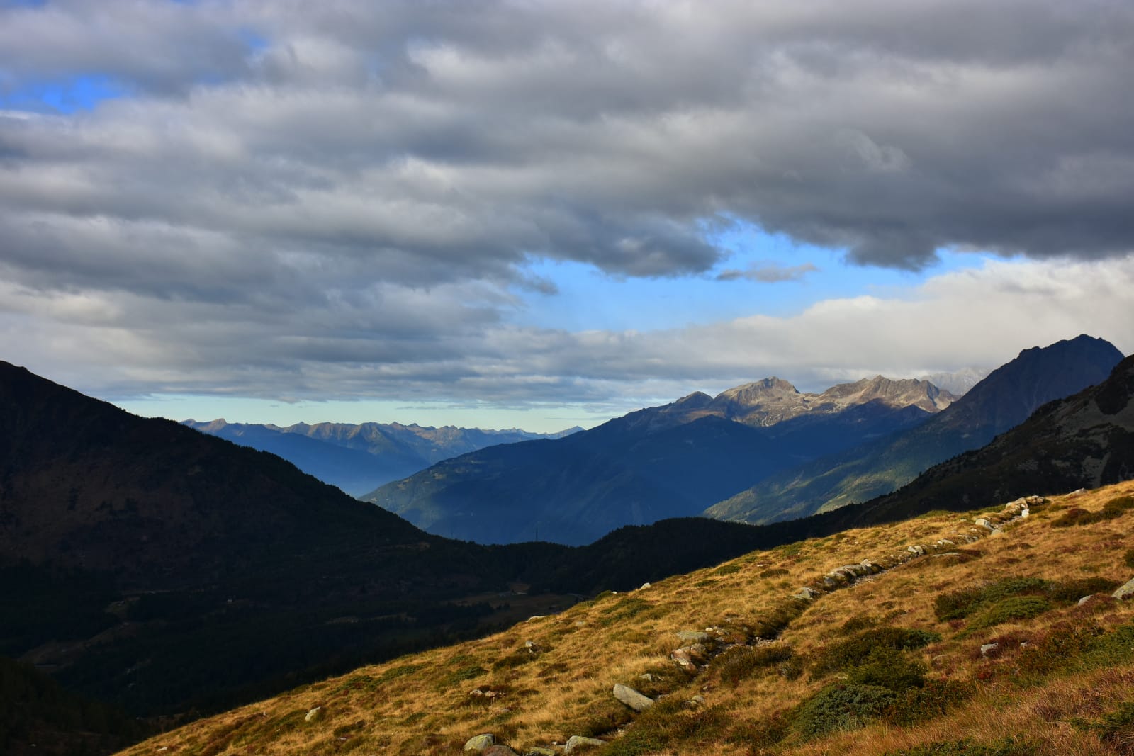 Vista cielo limpido, ma contraddistinto da nuvole sparse e montagne coperte da un erba pallida