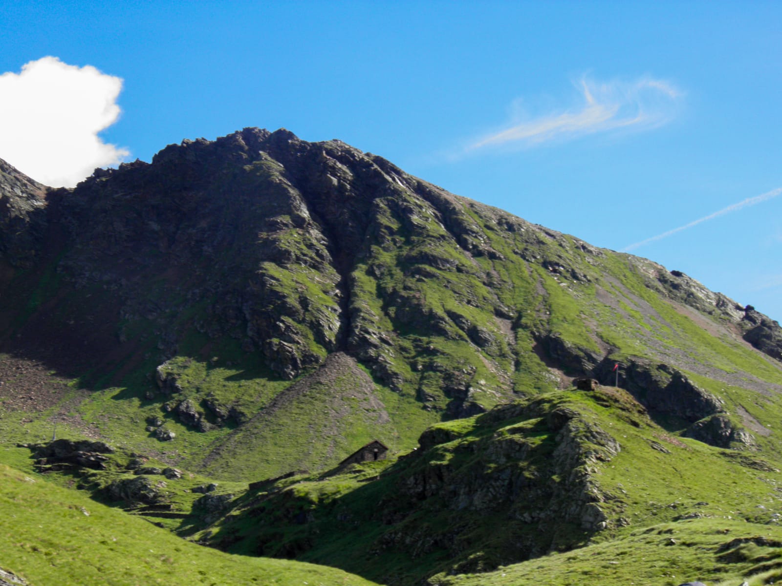 Vista di una piccola montagna completamente verde e riscaldata dal sole e da un cielo cristallino