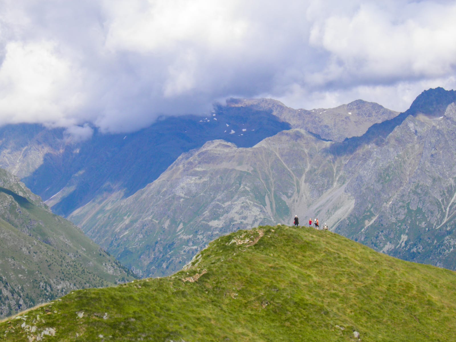 Vista montagne verdi dall'alto che toccano quasi le nuvole di un cielo sereno