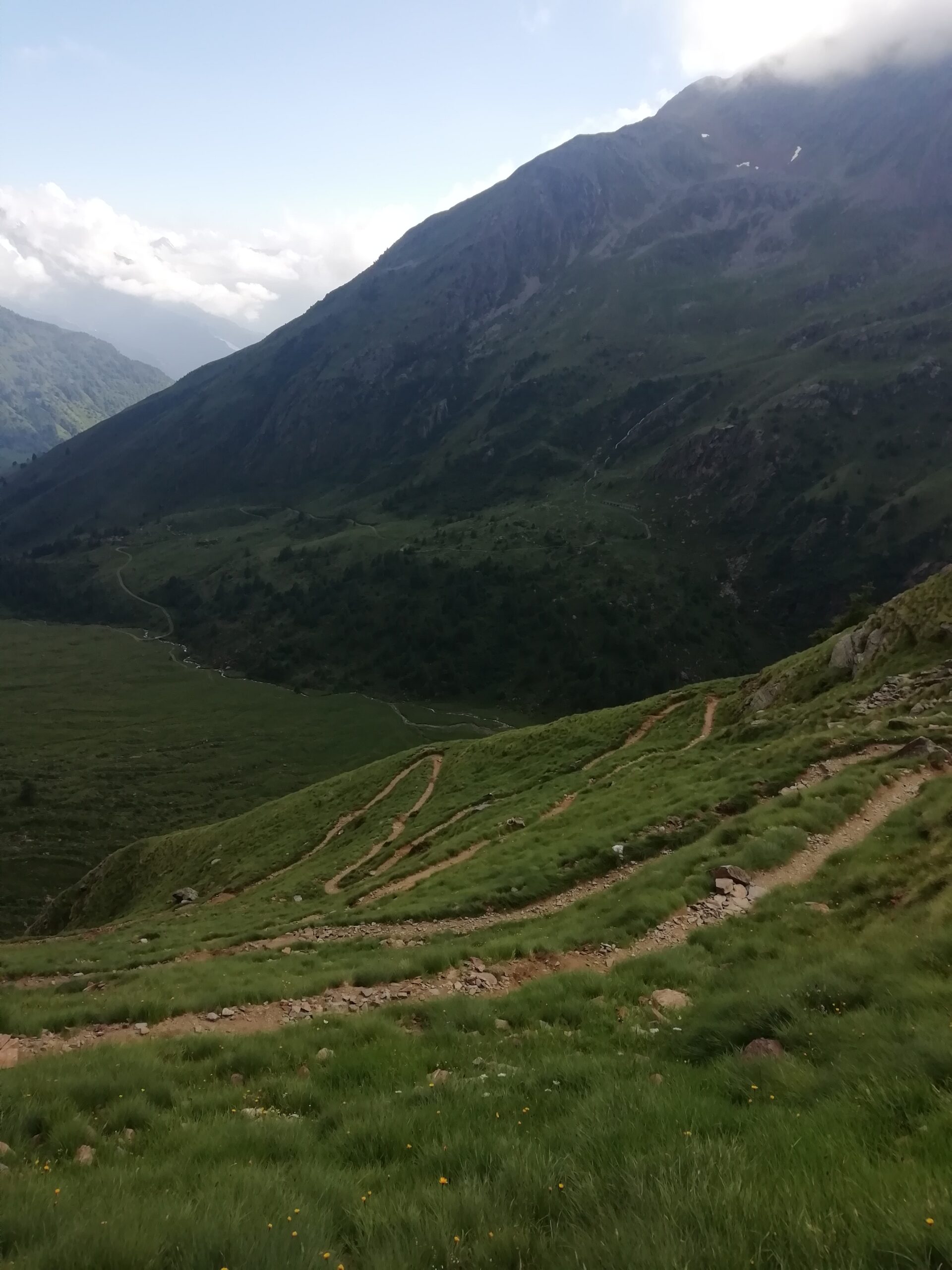 Vista di un piccolo sentiero che riporta alla montagna con un cielo limpido e poche nuvole